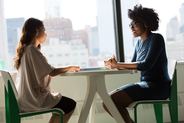 Two employees chatting during a workplace training session.